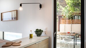 A modern kitchen with a wooden countertop, a bowl of avocados, a bottle of olive oil, and a hanging light fixture. - Fos Villa your place under the Cretan Sun with private heated pool (Chania)