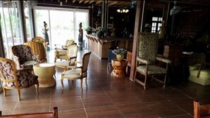 A spacious lobby with a variety of seating options, including armchairs and a sofa, and a large wooden coffee table. - Coffee&Homestay568 Branch 2 (Muang Suang)
