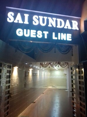 Ein Hotel Eingang mit einem Schild, das 'SAI SUNDAR GUEST LINE' zeigt.