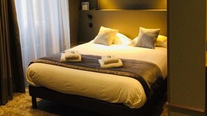 A modern hotel room with a large bed, a bedside table, and a nightstand. - Hotel Armoricaine (Saint-Malo)