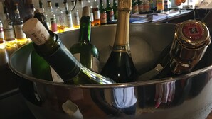 A bar area with a large metal sink filled with bottles of champagne and other alcoholic beverages. - Hotel Armoricaine (Saint-Malo)
