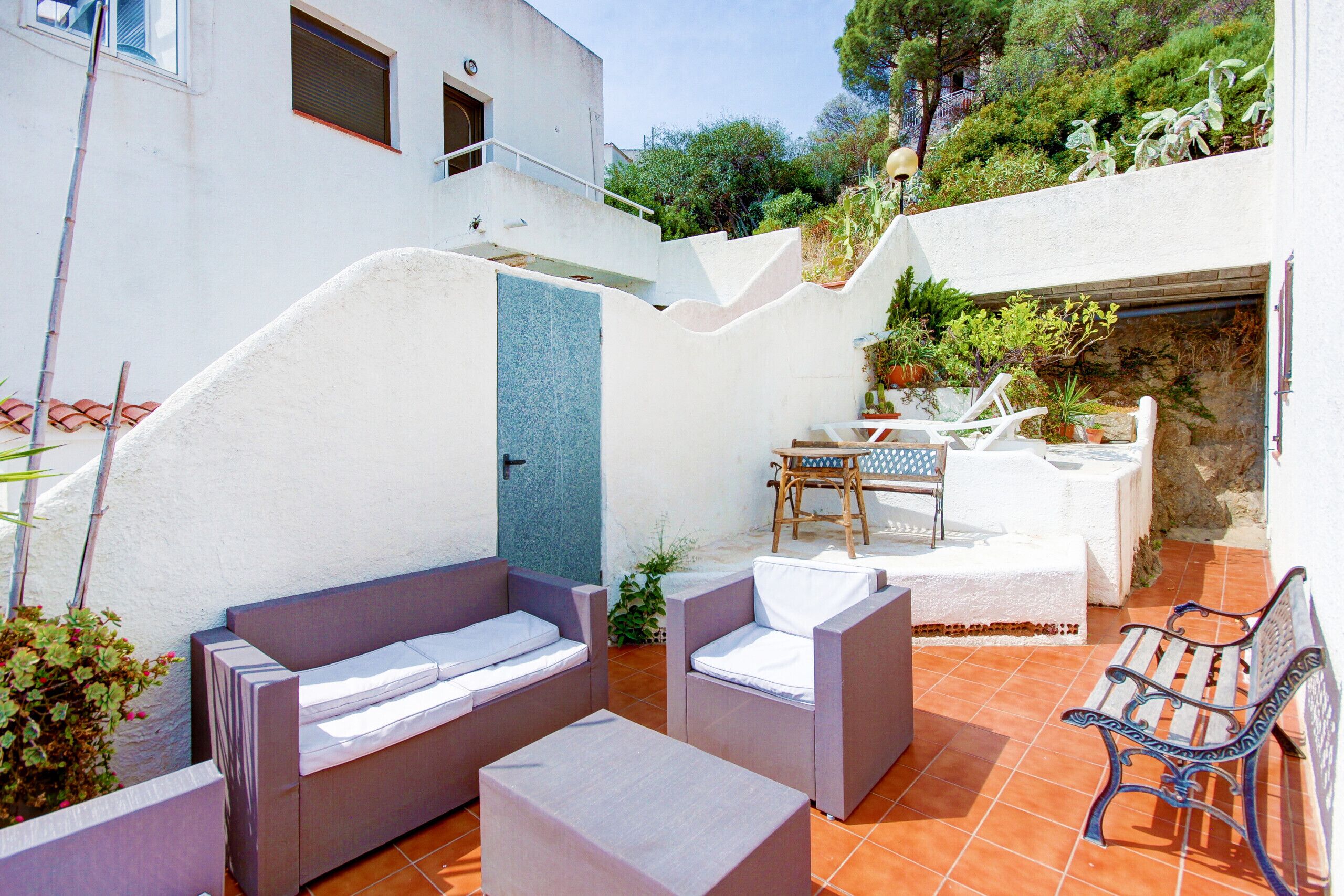 A patio with outdoor furniture, a table, and a bench.
