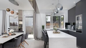 A modern kitchen with a central island, dark cabinetry, and stainless steel appliances. - Villa N Drage with pool  (Nin)
