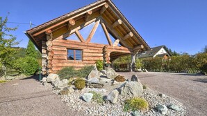 A log cabin with a sloped roof, a window, and a stone foundation. - 5-star log cabin with SPA (Erckartswiller)