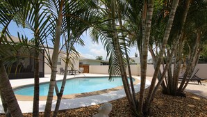 A swimming pool surrounded by palm trees and a statue. - Perfect recipe for relaxing, heated pool, walk to beach, bikes, stunning sunsets (Naples)