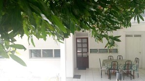 A covered patio area with a dining table and chairs, a door, and a window. - Holiday rental "AUTHENTICITY and CONVIVIALITY" in DESHAIES GUADELOUPE (Deshaies)
