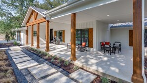 A covered patio area with outdoor seating and a stone pathway leading to the entrance.