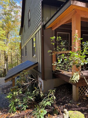 A wooden house with a porch, a small garden, and a solar panel. - Blue Ridge Pkway:Chef kitchen,Fenced YardPlayground,Hottub,5bdrms, 4public rooms (Boone)