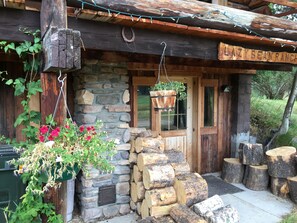 Una cabaña rústica con pared de piedra, vigas de madera y un letrero que dice 'LAZY BEAN RANCH'.