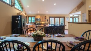A spacious kitchen with a dining area set for a meal. - The Ridge Chalet, an A-Frame Killington Home (Killington)
