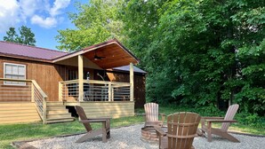 Eine Holzhütte mit einer Veranda, Sitzgelegenheiten im Freien und einer Kiesterrasse.