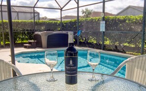 A poolside table with a bottle of wine and two glasses. - Windsor Palms Villa w/South Facing Private Pool & Hot Tub Close to Disney & Golf (Kissimmee)