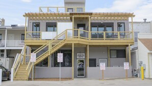 Un edificio de dos pisos con un balcón, una escalera y señales que indican restricciones de estacionamiento.