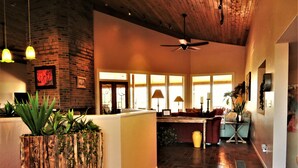 A spacious living area with a high ceiling, a wooden ceiling, and a large window providing natural light. - Rancho Venado Tucson, One of a kind, spiritual desert oasis in NE Tucson (Tucson)