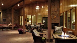 An indoor patio area with wooden flooring, multiple seating arrangements, and a central fire feature. - Rancho Venado Tucson, One of a kind, spiritual desert oasis in NE Tucson (Tucson)