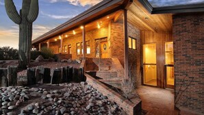 A modern building with a brick exterior, wooden deck, and a large cactus in the foreground. - Rancho Venado Tucson, One of a kind, spiritual desert oasis in NE Tucson (Tucson)