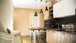 A kitchen with wooden cabinets, a white countertop, and hanging pendant lights. - Relais Villa Italia (Rome)