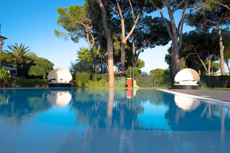 Una piscina al aire libre de temporada, una piscina infinita, sombrillas. Relais Villa Italia