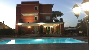 A two-story building with a swimming pool in front. - Relais Villa Italia (Rome)