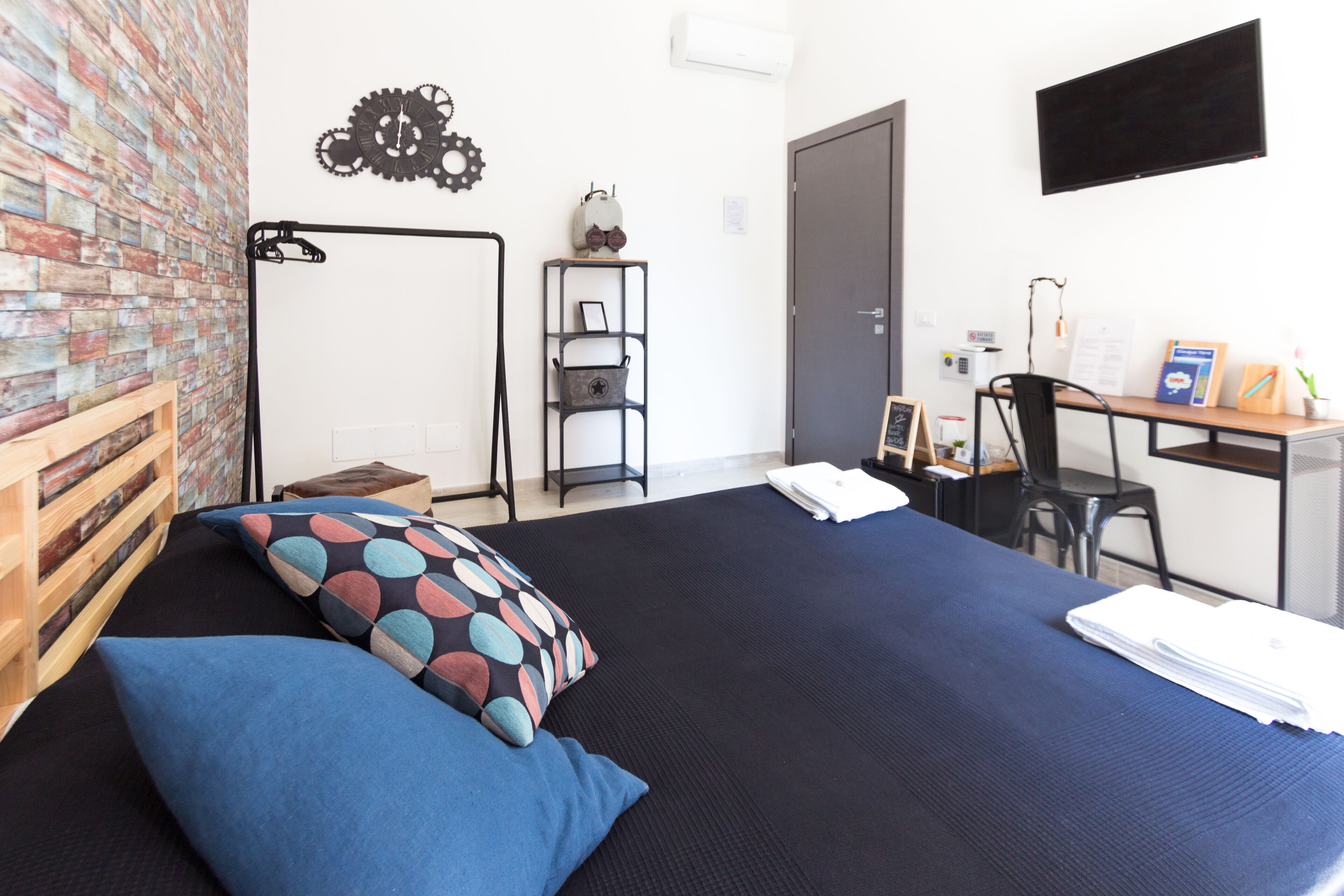 Un dormitorio con cama, escritorio y silla.