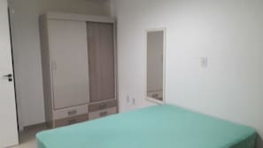 Une chambre à coucher avec un lit, une armoire et un miroir.