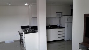 Een moderne keuken met witte kastjes, een zwart aanrecht en een ingebouwde magnetron.