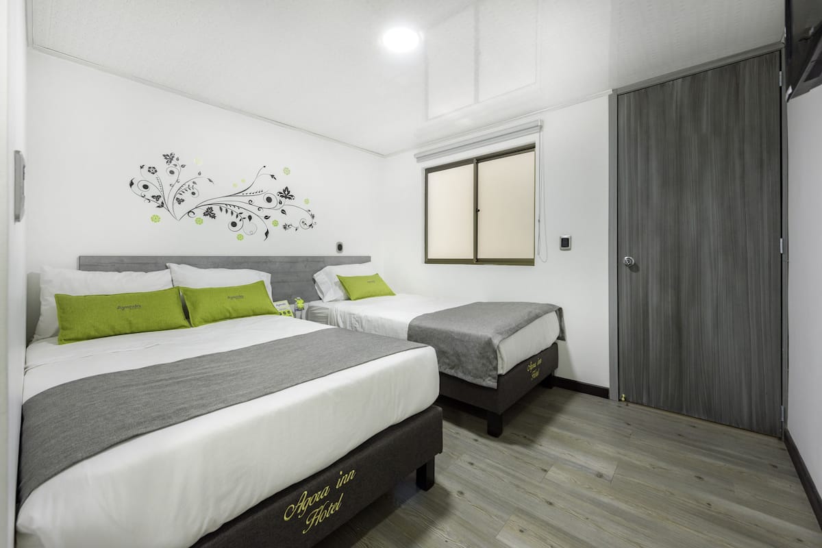 A hotel room with two beds, a wardrobe, and a decorative wall mural.