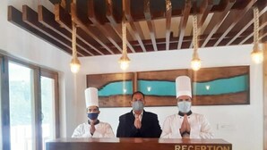 Un mostrador de recepción con el letrero "RECEPTION", y tres personas detrás.