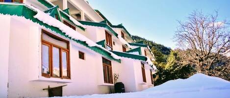 A building with a traditional architectural style, featuring a sloped roof and wooden windows.