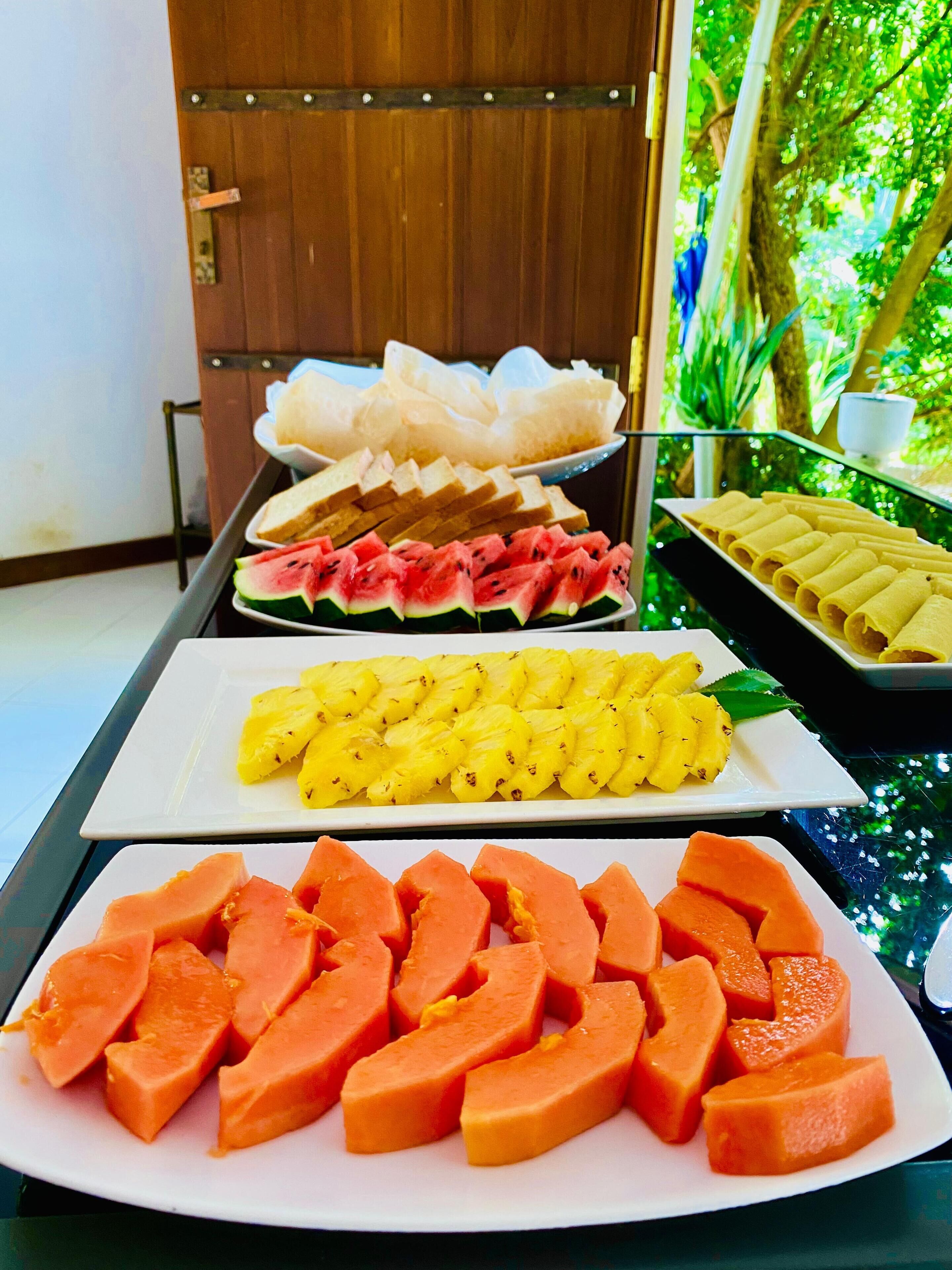 Une table de buffet proposant une variété de fruits et de plats.
