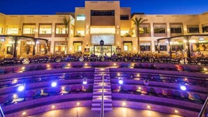 Un hotel con patio central, varios balcones y una entrada bien iluminada.