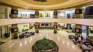 Un vestíbulo amplio con zona de estar central, varios niveles y un mostrador de recepción.