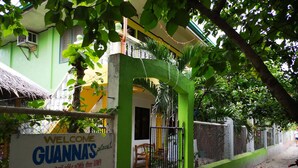 Un cancello verde con un cartello di benvenuto a Guannas place.