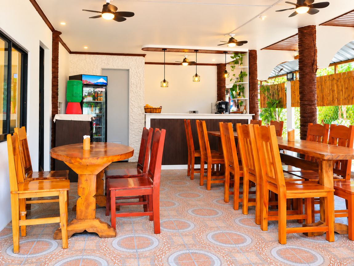 Un restaurante con zona de comedor central, barra y cocina.