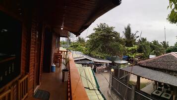 A wooden building with a balcony overlooking a market area.