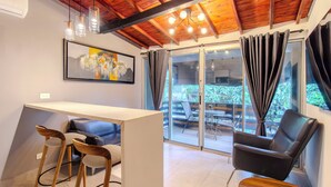 Una habitación moderna con comedor, sofá, sillón y mesa.