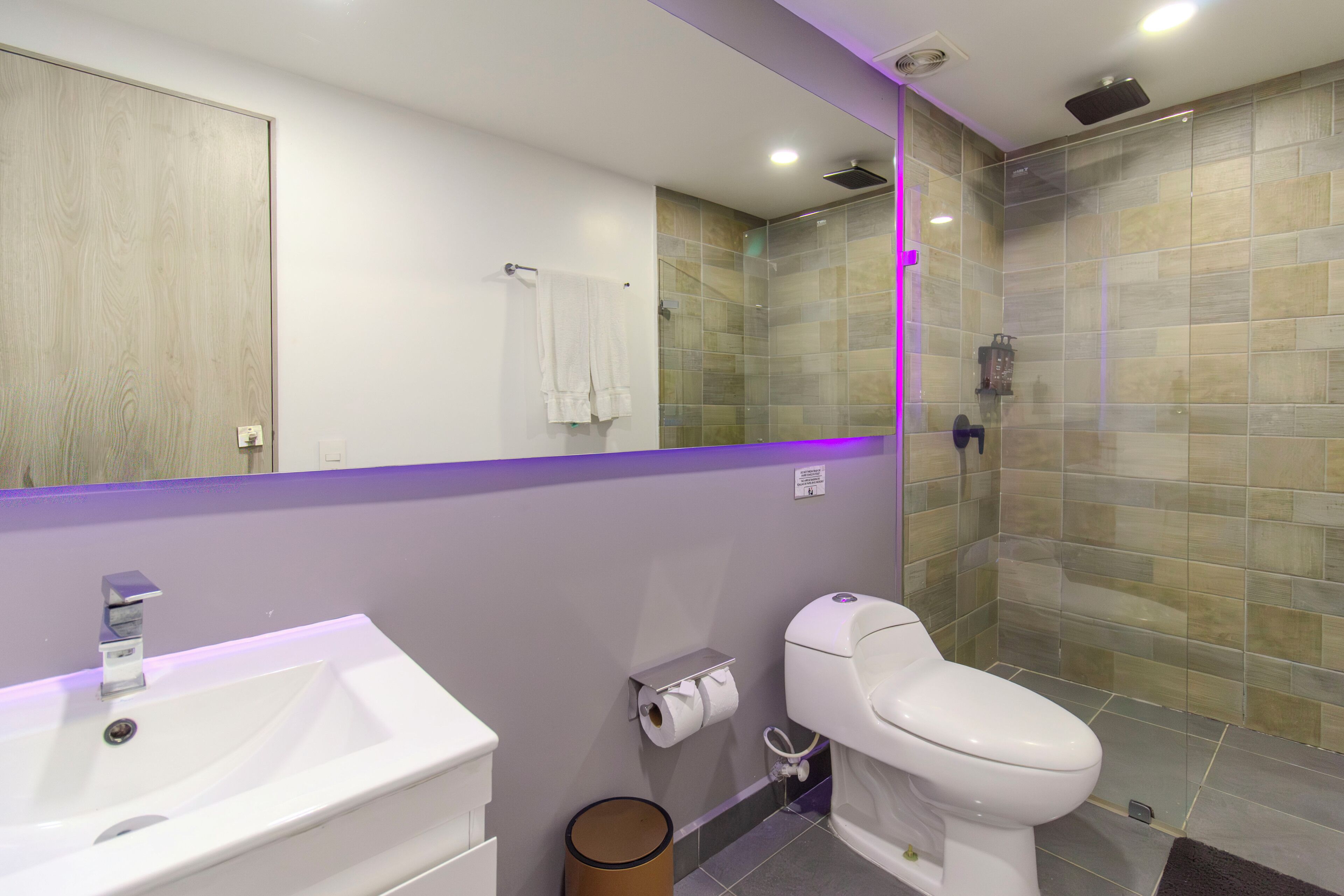 A modern bathroom with a sink, toilet, and shower area.