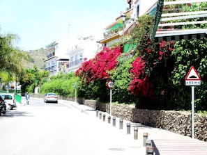 A street with a speed limit sign of 40, a height restriction sign of 53 meters, and a pedestrian walking on the sidewalk. - Hotel Al Andalus (Torrox)