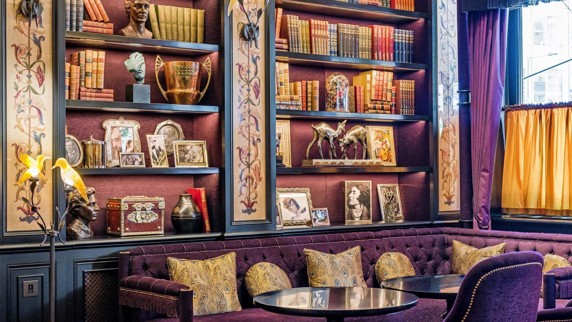 A room with a bookshelf, a sofa, and a table.
