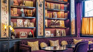 A room with a bookshelf, a sofa, and a table.