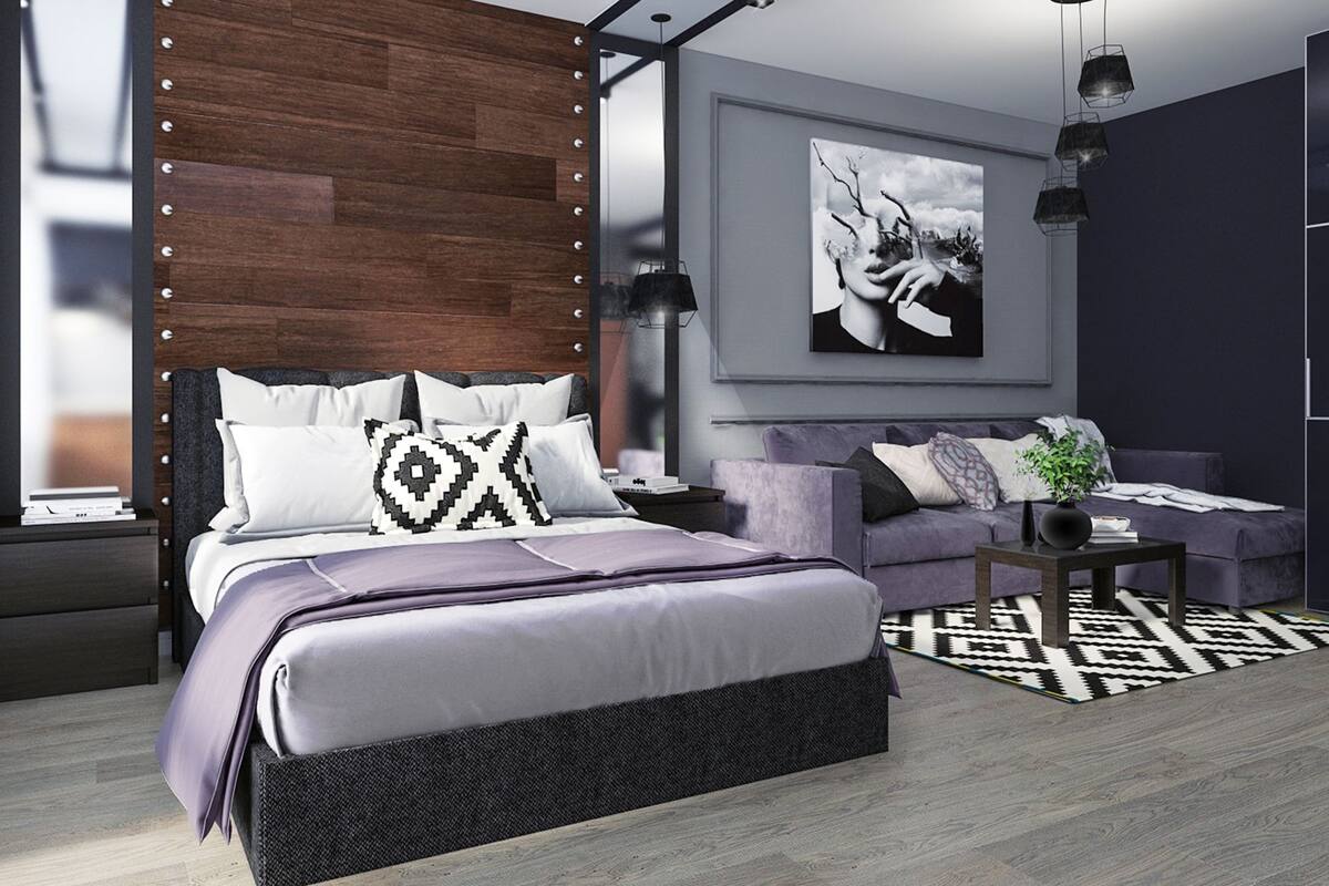 A modern bedroom with a large bed, a sofa, a coffee table, and a painting on the wall.