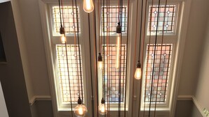 A staircase with a wooden railing and hanging light fixtures. - The Fleece Hotel (Richmond)