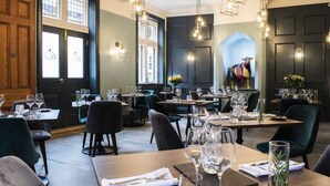 A restaurant with multiple tables set for dining, featuring a mix of chairs and booths. - The Fleece Hotel (Richmond)