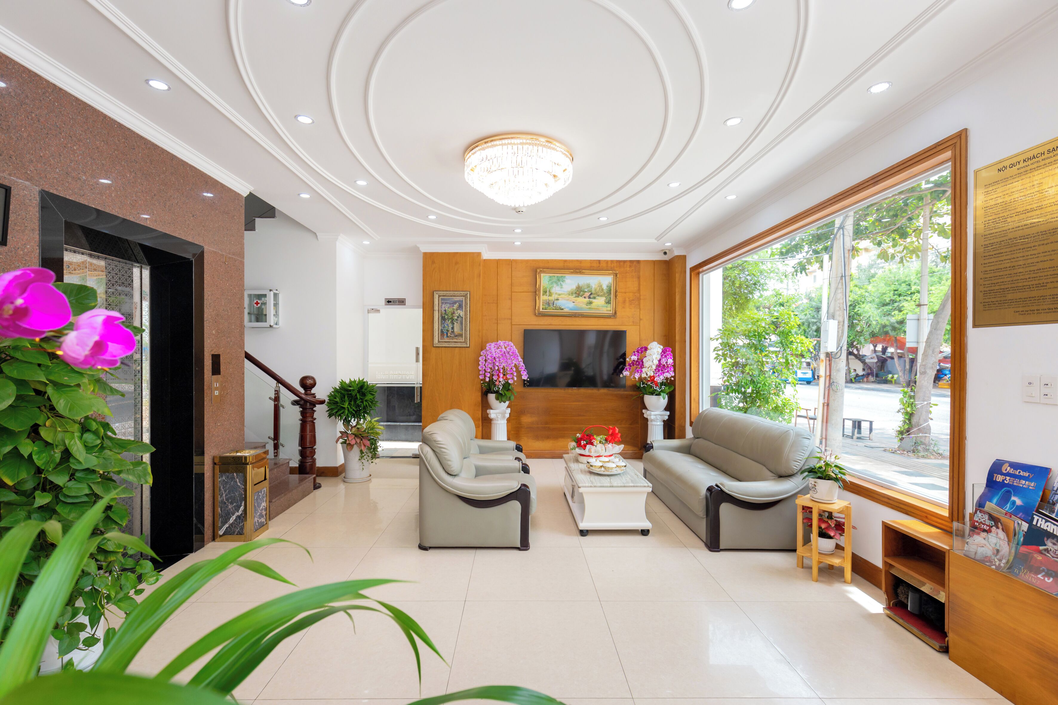 Un moderno vestíbulo de hotel con mostrador de recepción, zona de estar y amplios ventanales que ofrecen vistas al exterior.
