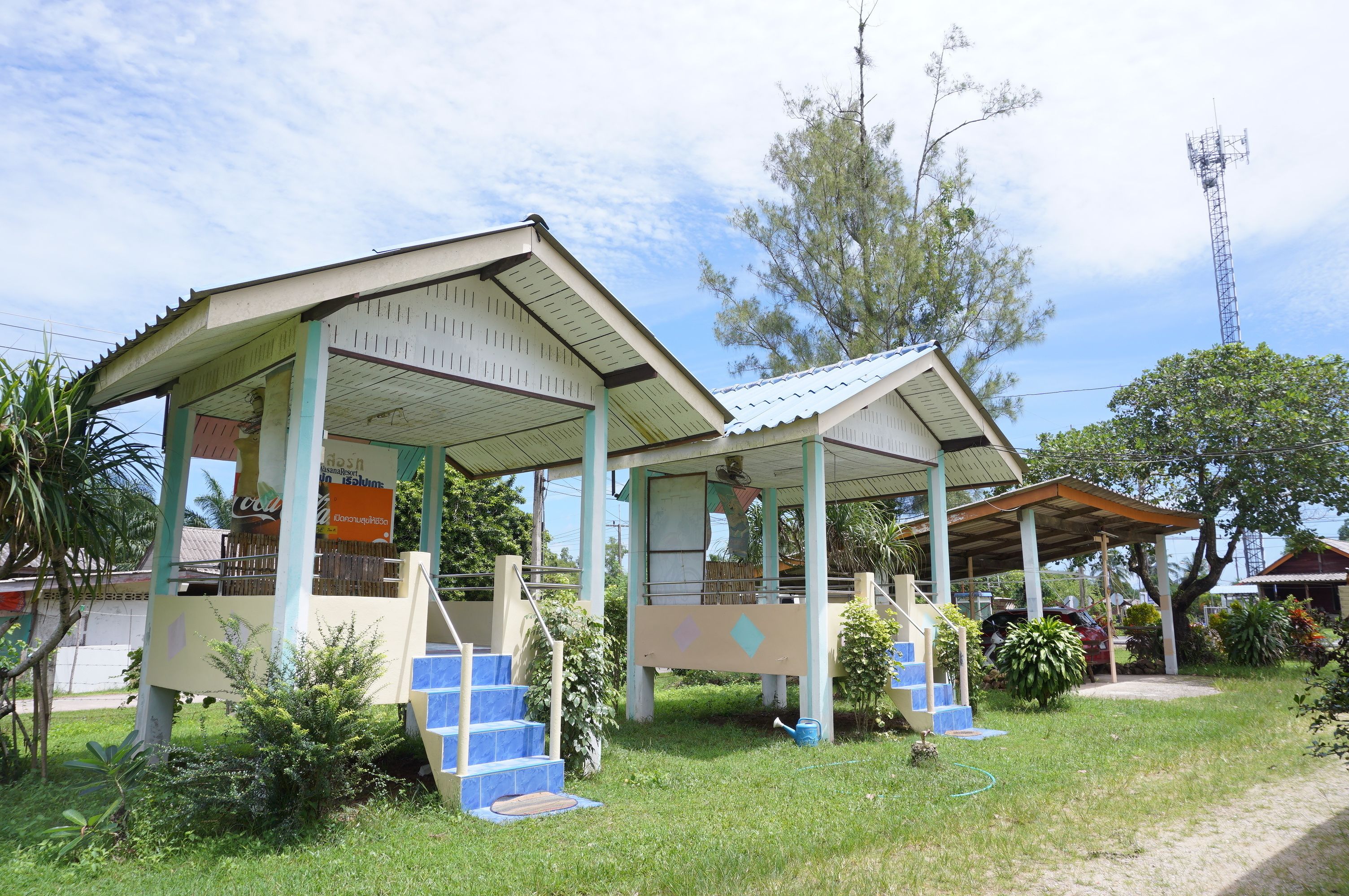 A two-story building with a covered porch and a staircase leading to the upper level.