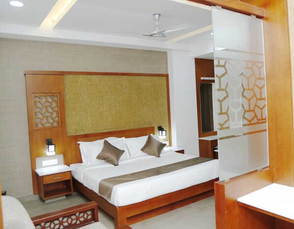Een moderne hotelkamer met een houten bed, nachtkastje en plafondventilator.
