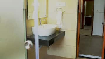 Un baño con un lavamanos blanco, un espejo y una toalla colgada en la pared.