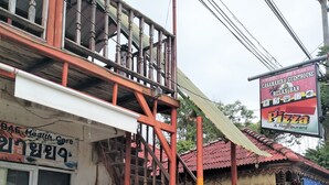 A building with a staircase, a health care center sign, and a pizza restaurant sign. - Casamarina Guest House (Ko Chang)