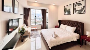 A modern hotel room with a large bed, a TV, a desk, and a view of the city through the window. - Spacious Saigon (Ho Chi Minh City)