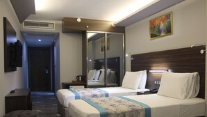 A hotel room with two beds, a TV, a mirror, and a painting on the wall. - Hotel Minerva Pazar (Pazar)